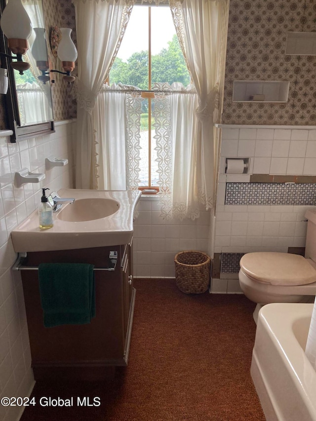 bathroom with tile walls, vanity, and a wealth of natural light