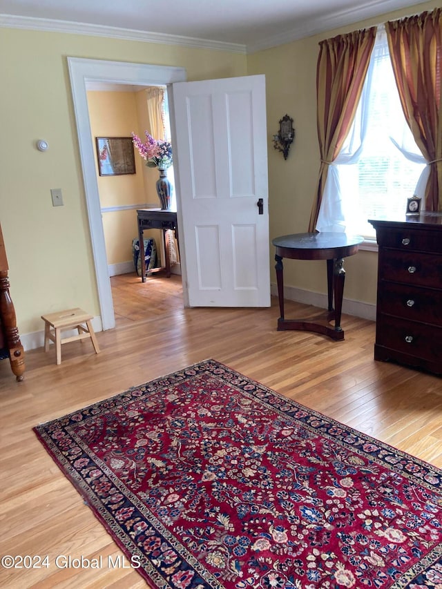 interior space with light wood-type flooring and ornamental molding