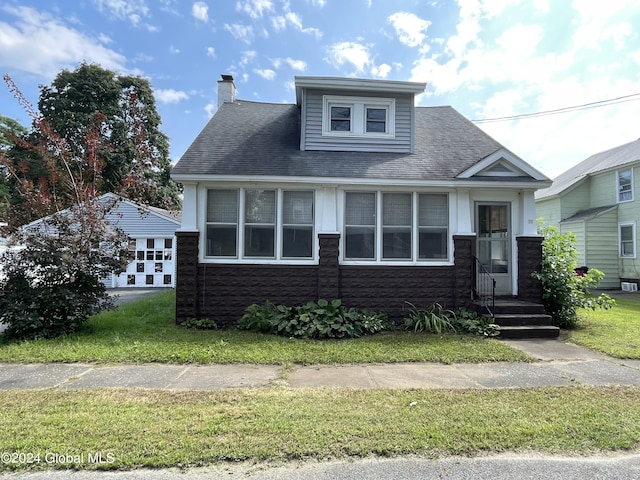 view of front of property featuring a shingled roof and a chimney