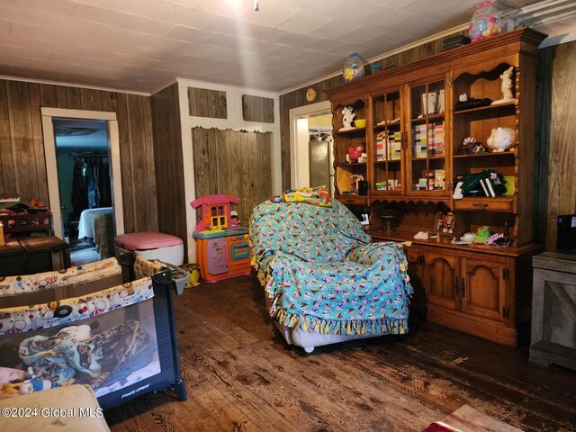 sitting room featuring wooden walls and dark hardwood / wood-style floors