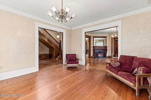 living room with hardwood / wood-style flooring, a notable chandelier, and ornamental molding