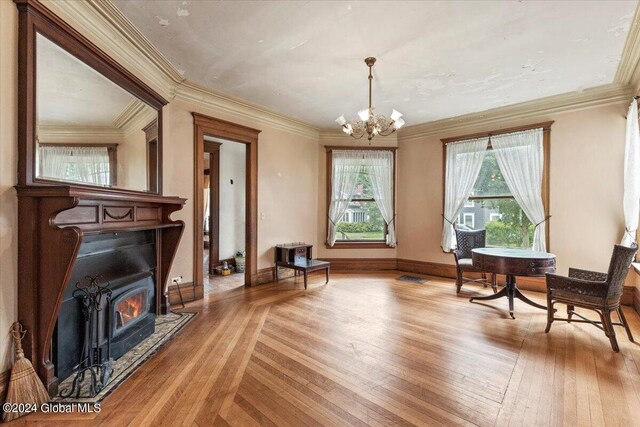 living area featuring a notable chandelier, light parquet flooring, and ornamental molding