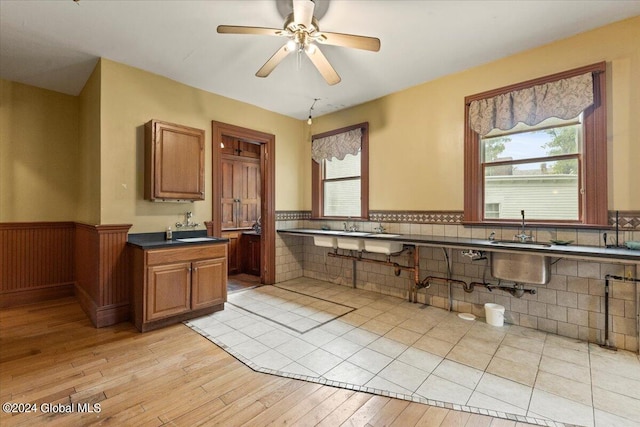 kitchen featuring ceiling fan, decorative backsplash, light hardwood / wood-style flooring, and sink