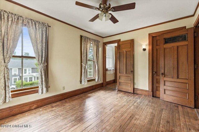 unfurnished bedroom with ceiling fan, hardwood / wood-style flooring, and ornamental molding