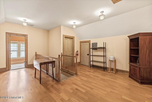 additional living space featuring light hardwood / wood-style floors and lofted ceiling