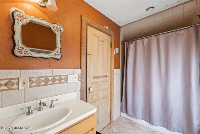 bathroom featuring tile walls, a shower with shower curtain, vanity, and tile patterned floors