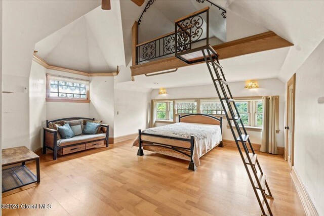 bedroom with a high ceiling and light wood-type flooring