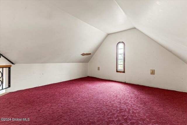 additional living space with carpet floors and vaulted ceiling