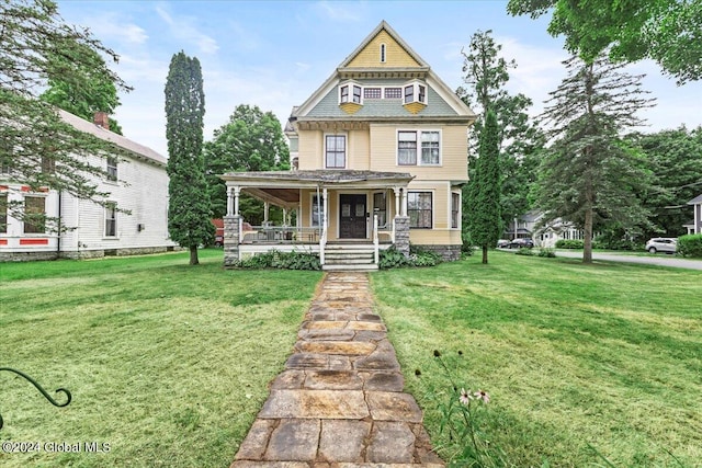 victorian house featuring a front yard and a porch