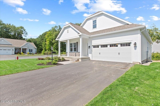 craftsman inspired home with a front yard, a garage, and covered porch