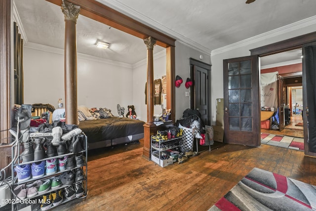 bedroom featuring ornamental molding, wood-type flooring, french doors, and ornate columns