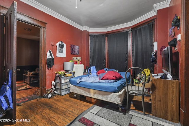 bedroom featuring radiator heating unit, hardwood / wood-style flooring, and crown molding