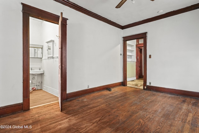 empty room featuring baseboards, wood finished floors, a ceiling fan, and crown molding