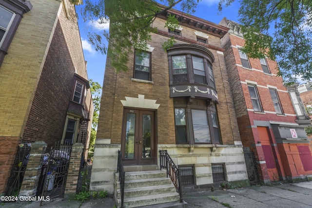 view of front of property with entry steps, french doors, and brick siding