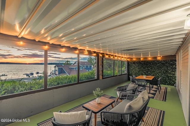 sunroom featuring a water view