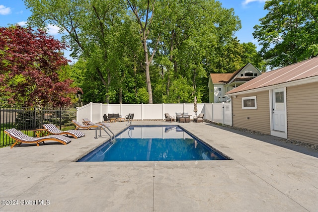 view of swimming pool featuring an outbuilding and a patio