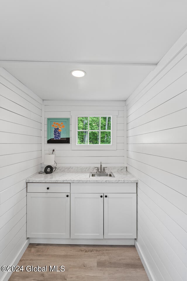 bathroom featuring vanity, wood walls, and hardwood / wood-style floors