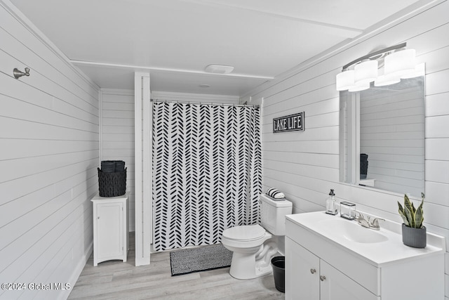 bathroom featuring toilet, hardwood / wood-style floors, vanity, wood walls, and a shower with curtain