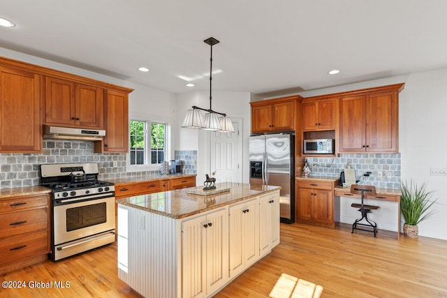 kitchen featuring light hardwood / wood-style flooring, decorative light fixtures, light stone countertops, a center island, and stainless steel appliances