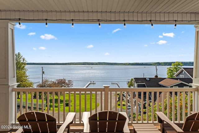 wooden deck with a lawn and a water view