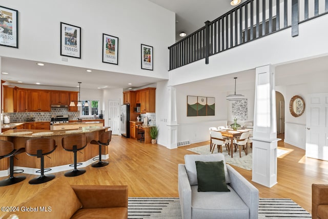 living room featuring a high ceiling and light hardwood / wood-style flooring