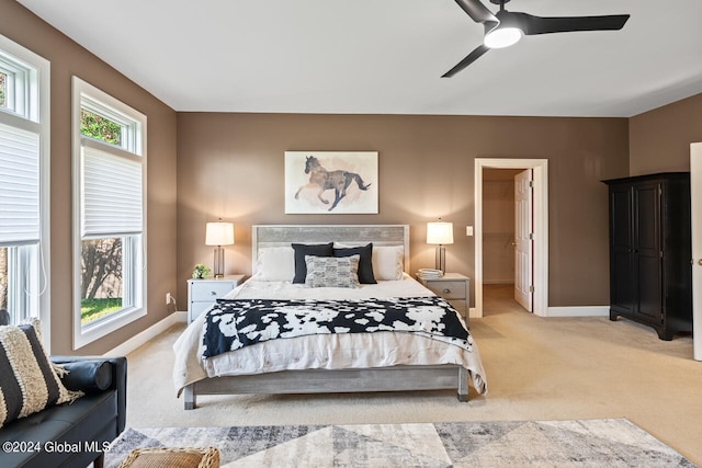 carpeted bedroom with ceiling fan and ensuite bath