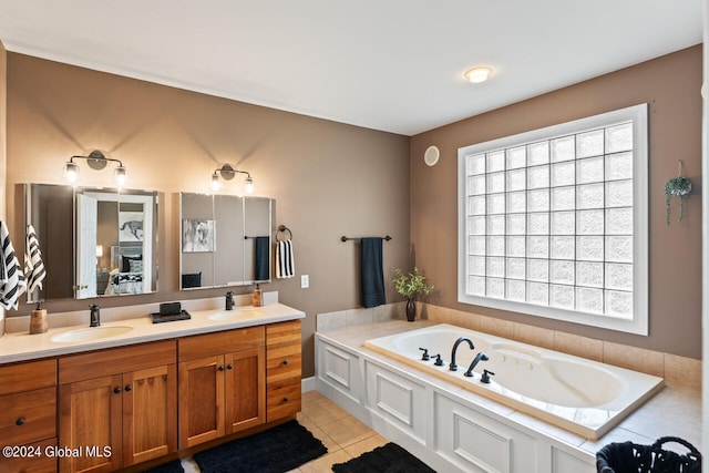 bathroom with a washtub, tile patterned floors, and vanity