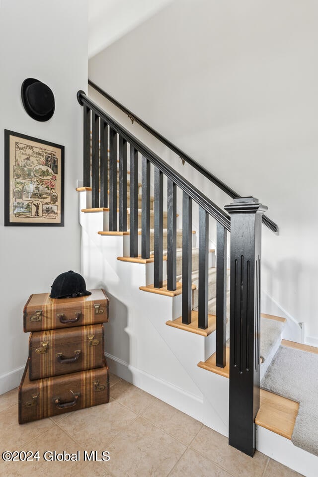 stairway with tile patterned floors