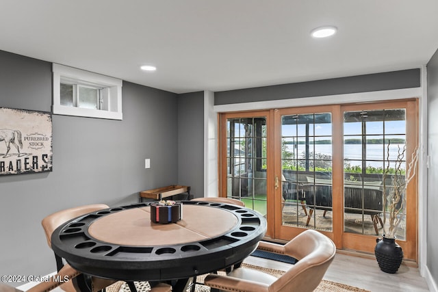 dining area with hardwood / wood-style floors and a water view