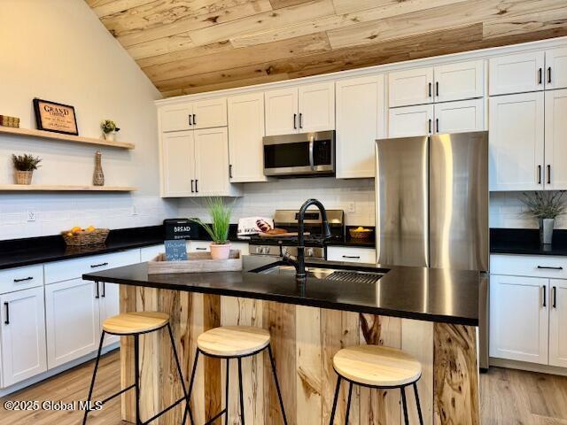 26 N 2nd Ave, Broadalbin, NY 12025 - kitchen with stainless steel appliances, wood ceiling, vaulted ceiling, white cabinets, and backsplash
