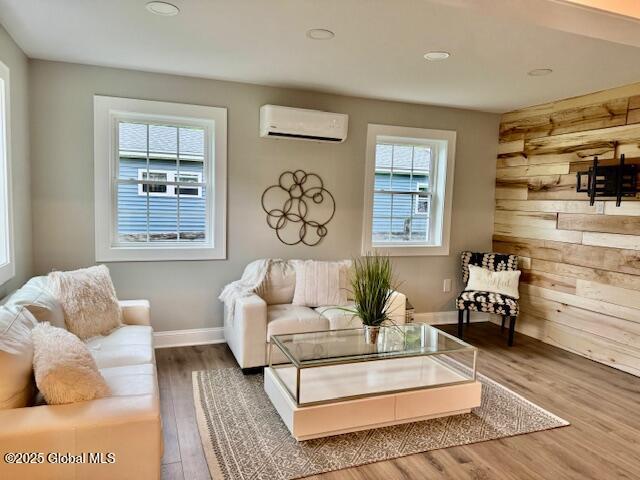 26 N 2nd Ave, Broadalbin, NY 12025 - living room featuring a wall unit AC, wood finished floors, wooden walls, and recessed lighting