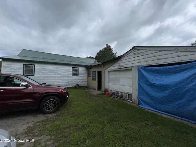 view of side of property featuring a lawn and a garage