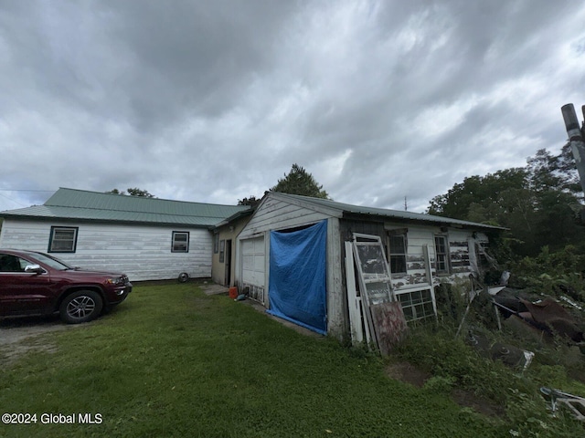 exterior space featuring a garage and a yard