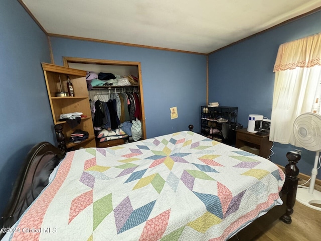 bedroom with hardwood / wood-style floors, ornamental molding, and a closet