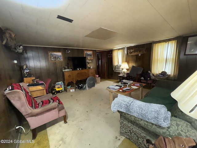 living room featuring wood walls, a healthy amount of sunlight, and concrete floors