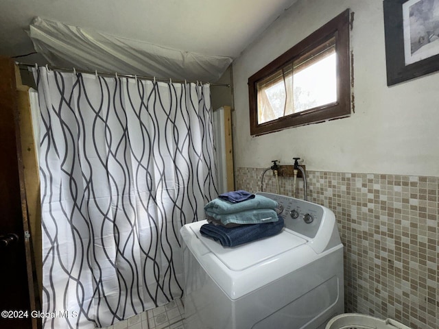 bathroom featuring tile patterned flooring, tile walls, washer / dryer, and shower with separate bathtub