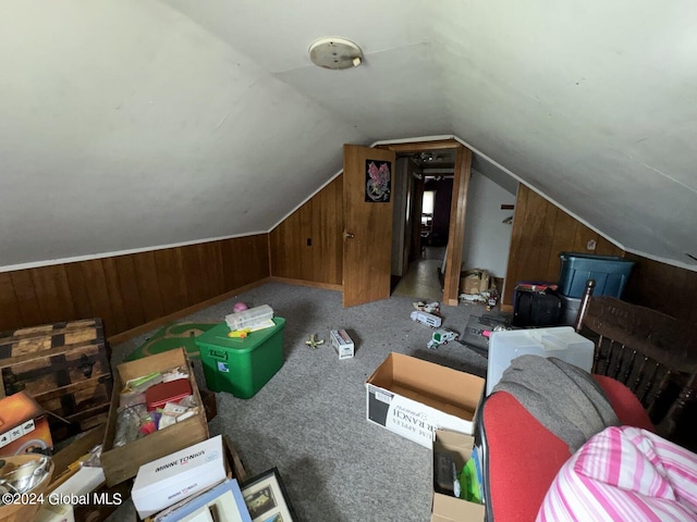 bonus room with wood walls, vaulted ceiling, and carpet