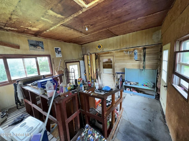 miscellaneous room with wooden walls and concrete floors