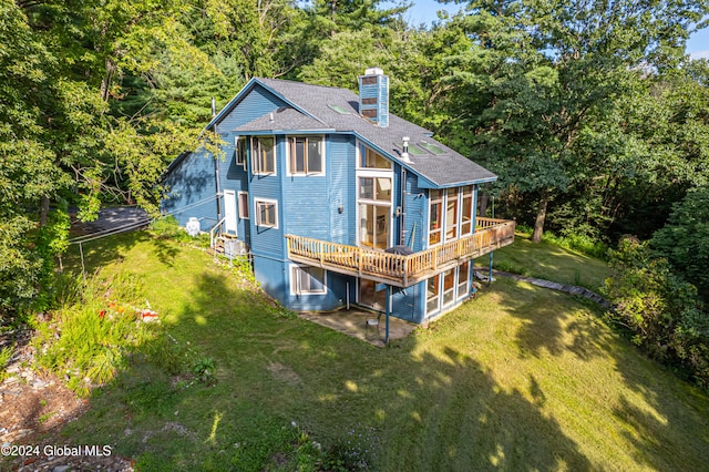 back of property with a wooden deck and a yard