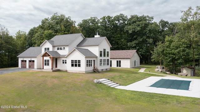 view of front of home with a front yard, a shed, and a covered pool