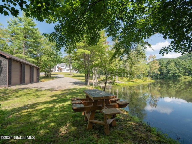 dock area with a water view and a yard