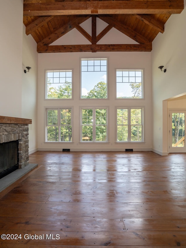 unfurnished living room with high vaulted ceiling and plenty of natural light