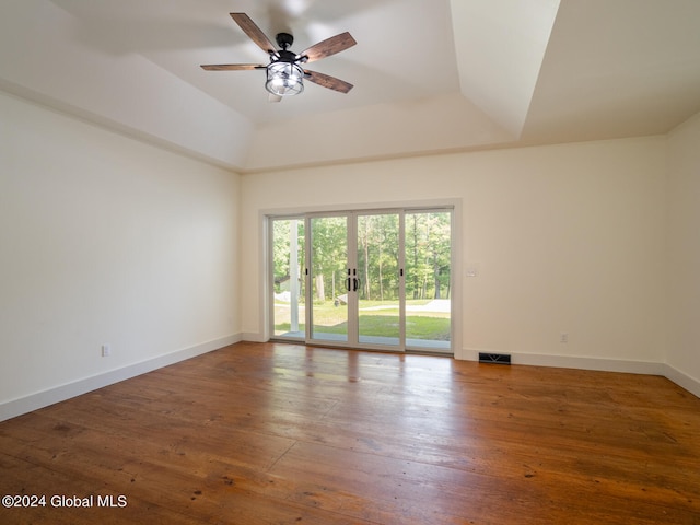 empty room featuring ceiling fan, a raised ceiling, and hardwood / wood-style floors