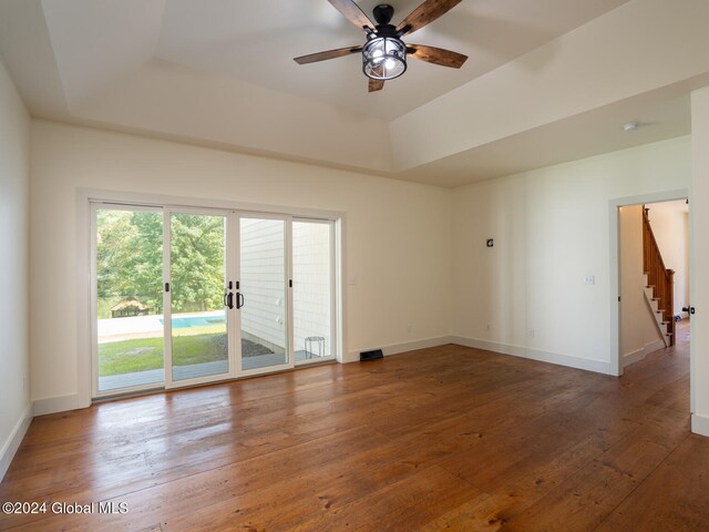 spare room featuring a raised ceiling, wood-type flooring, and ceiling fan