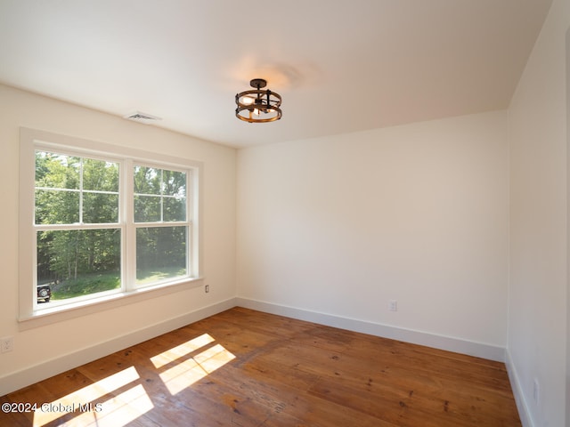 unfurnished room featuring hardwood / wood-style floors and plenty of natural light