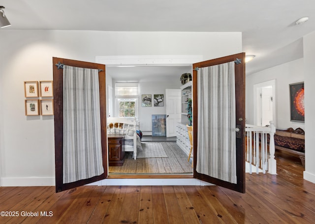 hallway with wood-type flooring and baseboards