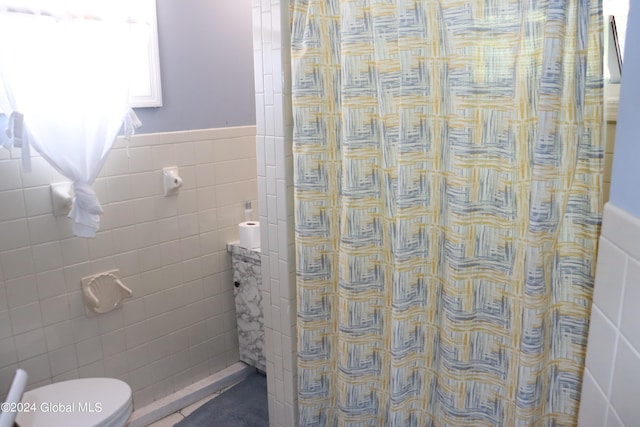 bathroom featuring tile walls, toilet, and walk in shower