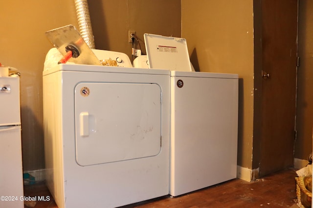 clothes washing area with washer and dryer and dark hardwood / wood-style floors