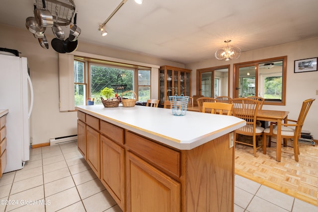 kitchen featuring light parquet flooring, track lighting, a center island, baseboard heating, and white refrigerator