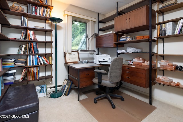 carpeted office space with a baseboard heating unit